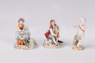 three porcelain figurines of children sitting on a bench with a dog