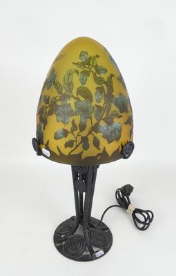 lampe dotée d'un abat-jour jaune orné de fleurs bleues et d'un cordon branché sur le socle