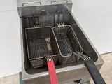 two fryers that are sitting on a cart