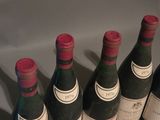 several bottles of wine are lined up in a row on a table