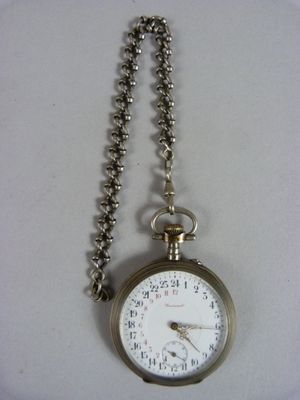 une montre de poche en argent avec une chaîne autour d'elle