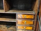 an old wooden cabinet with drawers and a rug on the floor
