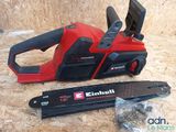 an electric chain saw is sitting on top of a piece of plywood