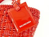 a red bag with a tag attached to it