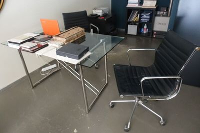 a desk with a chair and a laptop on it