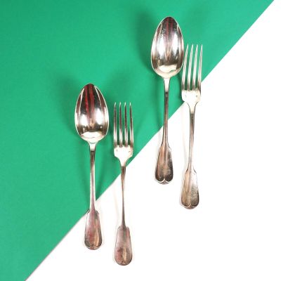 trois fourchettes et deux cuillères sur une table verte et blanche