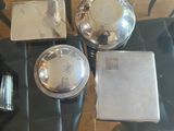 a glass table with silver dishes on it in a room