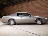 a silver car parked in a garage next to a brick wall