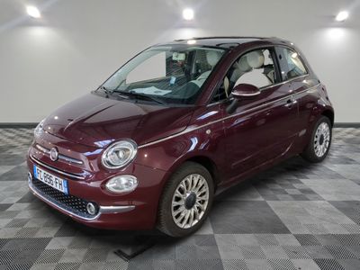 la petite voiture rouge est garée sur un carrelage à carreaux