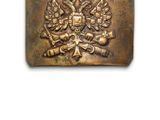 un gros plan d'une boucle de ceinture en laiton ornée d'un blason