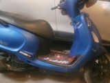 a blue scooter parked next to a white car