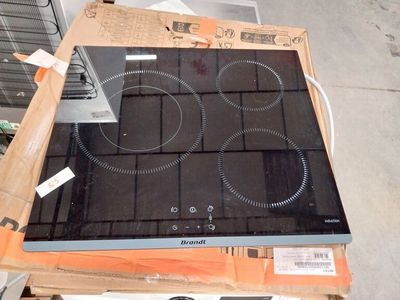 une plaque de cuisson noire posée sur une palette dans un entrepôt