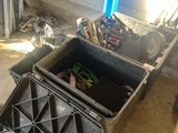 une boîte noire contenant des outils, posée par terre