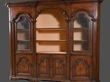 une bibliothèque ancienne en noyer, avec des portes vitrées et des étagères