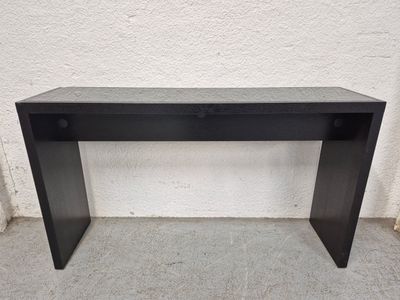 une console noire posée sur un sol en ciment