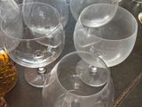 many glasses and a bottle of liquor sitting on a table