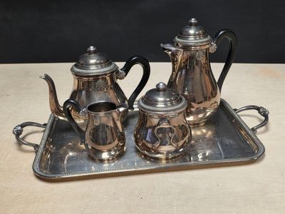 a silver tray with a silver tea set on it