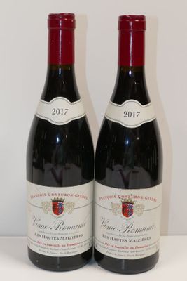 deux bouteilles de vin posées sur une table l'une à côté de l'autre