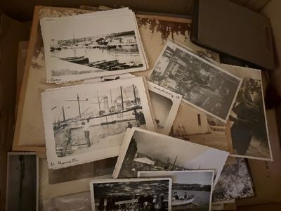 a box full of old photos of people and boats