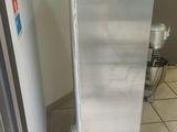 a red fire hydrant sitting next to a stainless steel refrigerator