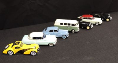 several toy cars are lined up in a row on a black surface