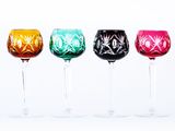 six different colored wine glasses lined up in a row on a white surface