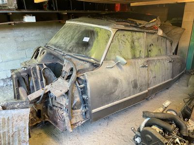 une vieille voiture qui prend la poussière dans un garage