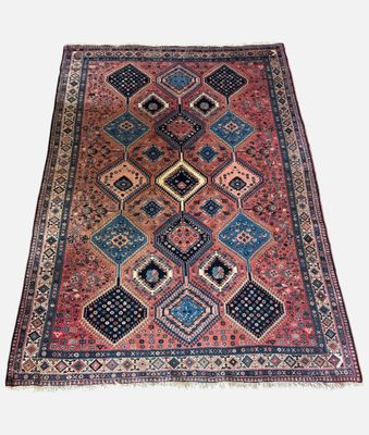 an antique persian rug with a geometric design