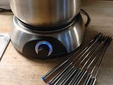 a pot of boiling water on a stove with a set of tongs next to it