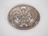 an antique silver plate with a flower design on it