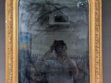 a reflection of a woman taking a picture in a mirror