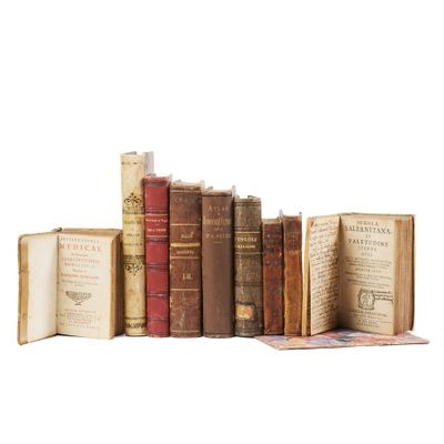 several old books are stacked on top of each other on a white surface