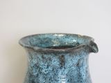 a blue vase that is sitting on a table