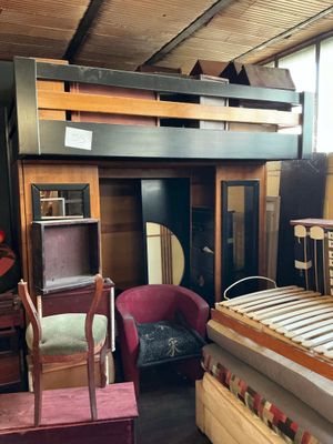 une pièce avec un lit, une chaise, un bureau et une mezzanine