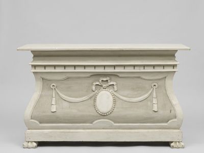 un coffre en bois blanc orné d'un motif décoratif sur le devant
