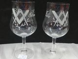 deux verres à vin posés sur une table, sur fond noir