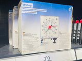 une boîte avec une horloge posée sur une étagère dans un magasin