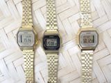 two watches are sitting side by side on a woven surface