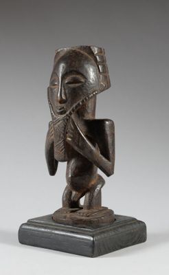 une statue en bronze représentant un homme jouant de la flûte