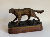 statue en bronze d'un chien sur un socle en bois sur fond blanc