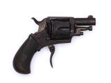un vieux pistolet est posé sur une surface blanche, devant un fond blanc