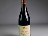 a close up of a bottle of red wine on a table