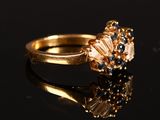 a close up of a gold ring with blue and white diamonds