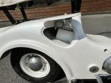 a white car with a golf cart on the back of it