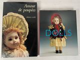 two books of dolls are sitting on a white surface