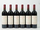 six bouteilles de vin sont alignées sur une surface blanche
