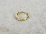 un gros plan d'une bague en or sertie de diamants posée sur une surface en marbre