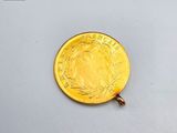a gold coin that is sitting on a white surface