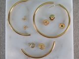 gold hoop earrings and earring set on a marble slab
