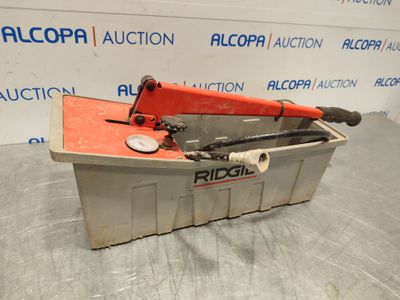 an orange and black pipe cutter sitting on top of a metal container